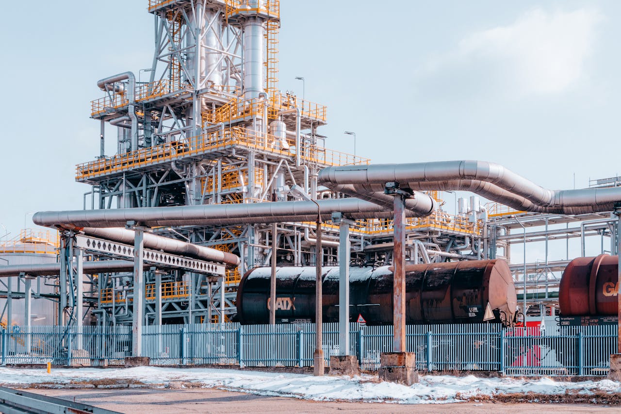 Oil refinery facility with tanker wagons in Trzebinia, Lesser Poland Voivodeship under a clear sky.